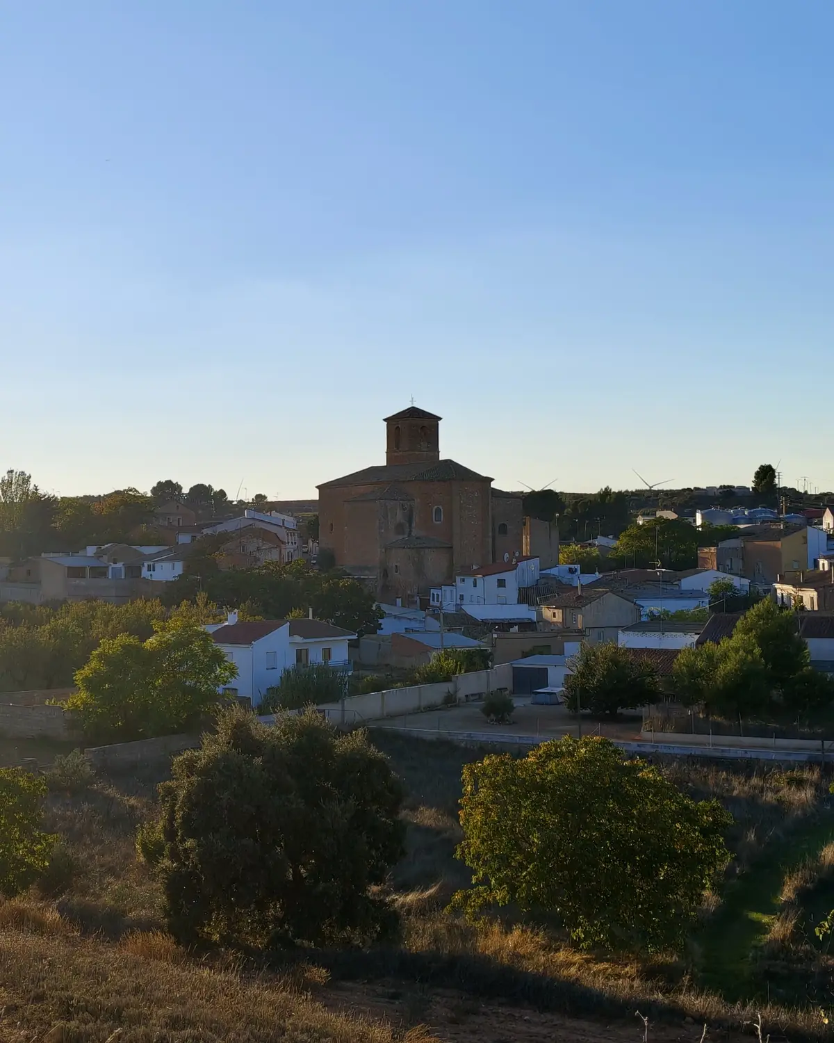 La Puebla del Salvador al atardecer, con la iglesia de la Transfiguración sobre el caserío